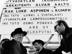 Kuvassa vasemmalla arkkitehti Alvar Aalto Alvar Aalto -museon rakennustyömaan kylttien edessä kahden muun miehen kanssa. Kuva Antti Bengts